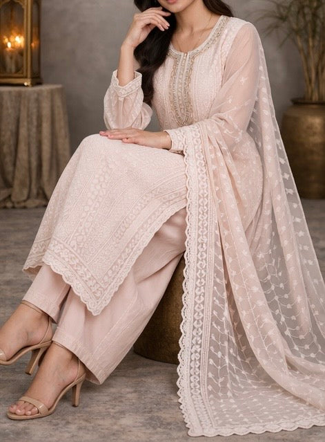 Elegant pastel pink suit crafted in dedicate embroidered fabric , featuring intricate threadwork on the neckline and panels , paired with a sheer floral dupatta for a graceful and timeless look