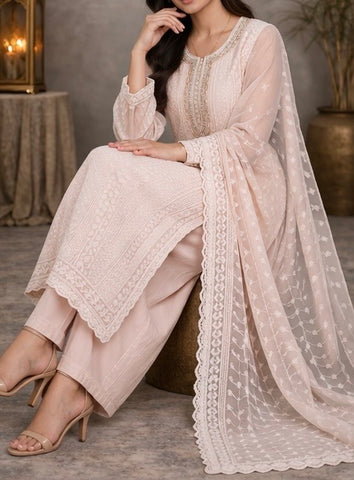 Elegant pastel pink suit crafted in dedicate embroidered fabric , featuring intricate threadwork on the neckline and panels , paired with a sheer floral dupatta for a graceful and timeless look
