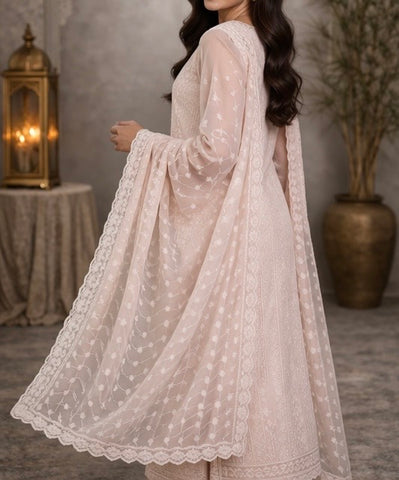 Elegant pastel pink suit crafted in dedicate embroidered fabric , featuring intricate threadwork on the neckline and panels , paired with a sheer floral dupatta for a graceful and timeless look