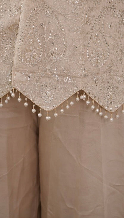 Ivory suit set crafted with dedicate hand embroidery, featuring a scalloped hem kurta paired with flowy palazzo pants
