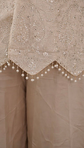 Ivory suit set crafted with dedicate hand embroidery, featuring a scalloped hem kurta paired with flowy palazzo pants