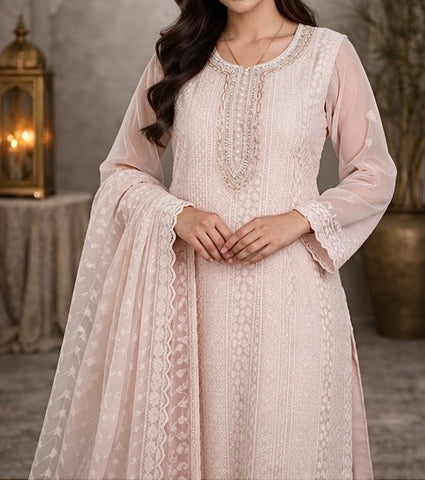 Elegant pastel pink suit crafted in dedicate embroidered fabric , featuring intricate threadwork on the neckline and panels , paired with a sheer floral dupatta for a graceful and timeless look